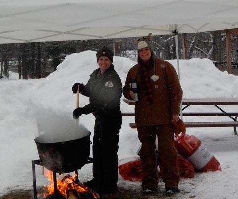 Stirring the soup cauldron with a canoe paddle is Ranger Corrine Hodapp (L) and ready to ladle soup is Krista Okerman (R)